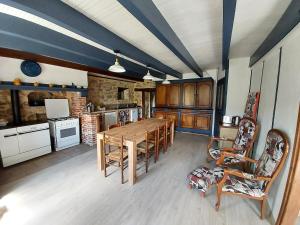 Una gran cocina con una mesa y sillas de madera. en Gîte in logement complet - 11 personnes - max 15, sous réserve, en Varennes-Saint-Honorat