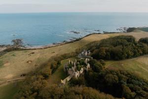 una vista aerea di un castello vicino all'oceano di Landal Whitekirk Hill a North Berwick