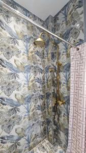 ein Bad mit einer Dusche und blauen und weißen Tapeten in der Unterkunft Urban flat in Chalkida + 16 Fotos