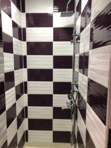ein Bad mit einer schwarz-weiß karierten Wand in der Unterkunft Danojlic 2 in Višegrad