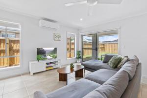 una sala de estar con un sofá y una mesa en Fresh and Stylish 4BR Getaway Near Local Parklands, en Marsden
