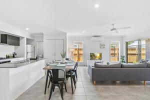 Una cocina y una sala de estar con una mesa y un sofá. en Fresh and Stylish 4BR Getaway Near Local Parklands, en Marsden
