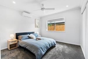 Un dormitorio con una cama y una ventana en Fresh and Stylish 4BR Getaway Near Local Parklands, en Marsden 11 fotos más