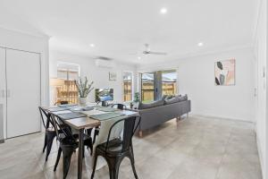 una sala de estar con una mesa y un sofá en Fresh and Stylish 4BR Getaway Near Local Parklands, en Marsden