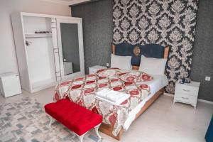 a bedroom with a large bed and a red chair at Kars Atapark Hotel in Kars
