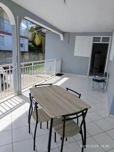 ein Holztisch und Stühle auf einem Balkon in der Unterkunft Villa Le Bananier in Sainte-Rose + 20 Fotos