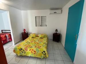 ein Schlafzimmer mit einem Bett mit gelber Decke in der Unterkunft Charmante maison avec vue sur mer - Plage à 1mn à pieds in Saint-Louis