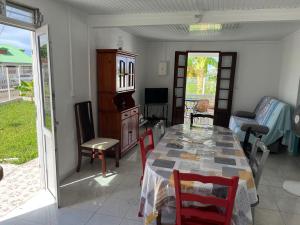 ein Esszimmer mit Tisch und Stühlen und einem Fernseher in der Unterkunft Charmante maison avec vue sur mer - Plage à 1mn à pieds in Saint-Louis