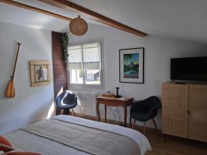 Μια τηλεόραση ή/και κέντρο ψυχαγωγίας στο Au Ptit bonheur avec parking motos et vélos et petit déjeuner inclus