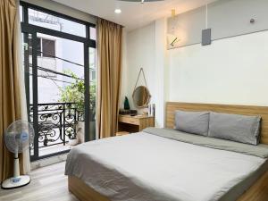 a bedroom with a bed and a large window at Four P Home in Ho Chi Minh City
