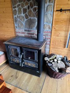 a stove in a room with a stone wall at Roubenka in Železná Ruda