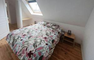 Trézény2 Bedroom Beautiful Home In Rospez的一间卧室配有一张带花卉棉被和桌子的床