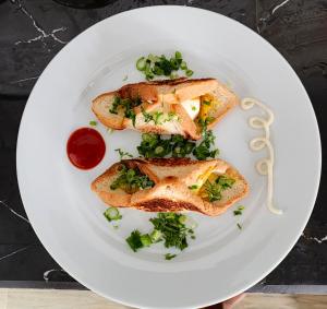 a white plate with two pieces of toast with greens at Junction 14 Villa in Dikwella North