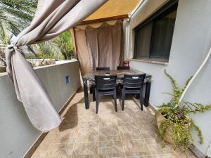 a patio with a table and chairs on a balcony at צימר חן בחד נס in Had Nes