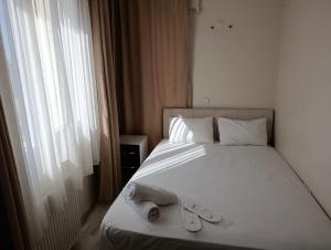 Un dormitorio con una cama con dos zapatos encima. en Mir Suit Hotel, en Buca