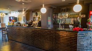 a bar with a brick wall and lights at TM Apart Hotel in Tbilisi City