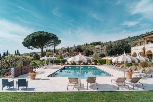 a pool at a resort with chairs and umbrellas at Il Falconiere Relais & Spa in Cortona
