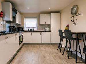 a kitchen with white cabinets and a table and chairs at Raven Lodge in Brigg