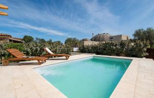 una piscina con panchina e sedia di Pet Friendly Home In San Teodoro a San Teodoro