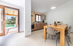 una cucina e una sala da pranzo con tavolo e sedie in legno di Pet Friendly Home In San Teodoro a San Teodoro