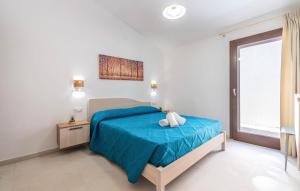 una camera da letto con un letto con lenzuola blu e una finestra di Pet Friendly Home In San Teodoro a San Teodoro
