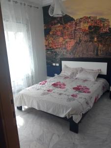 a bedroom with a bed with a painting on the wall at Appartement les jardins de Carthage in Carthage