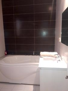 a bathroom with a white bath tub and a sink at Appartement les jardins de Carthage in Carthage