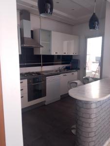a kitchen with white cabinets and a counter top at Appartement les jardins de Carthage in Carthage +3 photos