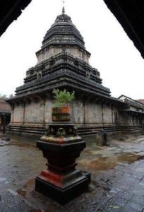 ein großes Gebäude mit einem Baum davor in der Unterkunft Heaven Beach AC Stay in Gokarn