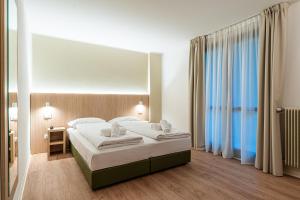 a hotel room with a bed and a large window at Hotel Bella Italia Piancavallo in Piancavallo