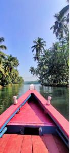 Ein rotes Boot auf einem Fluss, im Hintergrund Bäume in der Unterkunft Heaven Beach AC Stay in Gokarn