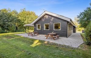 a house with a picnic table and two benches at Gorgeous Home In Farsø With Wifi in Hole +12 photos