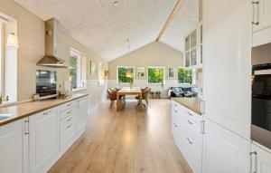 a kitchen with white cabinets and a wooden table at Gorgeous Home In Farsø With Wifi in Hole