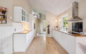 a kitchen with white cabinets and wooden floors at Gorgeous Home In Farsø With Wifi in Hole
