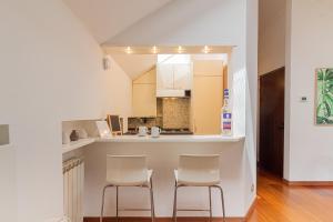 a kitchen with two white chairs and a counter at Il camino felice - 201 by Houset in Monza