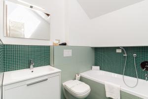 a bathroom with a toilet and a tub and a sink at Il camino felice - 201 by Houset in Monza