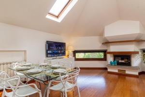 a dining room with a table and chairs and a fireplace at Il camino felice - 201 by Houset in Monza