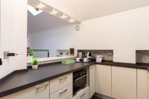 a kitchen with white cabinets and black counter tops at Il camino felice - 201 by Houset in Monza