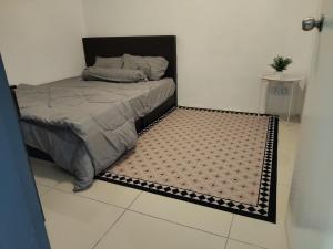 a small bed in a room with a rug at D' Ara SZ Homestay in Kubang Semang