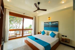 ein Schlafzimmer mit einem Bett und einem großen Fenster in der Unterkunft LIYA BEACH - Luxury Boutique Hotel in Ahangama in Ahangama