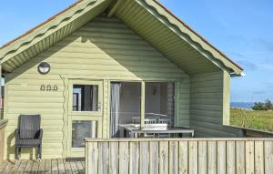 Pugdal2 Bedroom Beautiful Home In Hanstholm的露台上有一个温室，里面摆放着一张桌子和一把椅子。