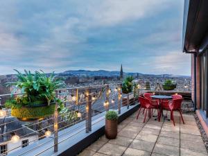 a patio with a table and chairs on a balcony at Novotel Edinburgh Centre in Edinburgh