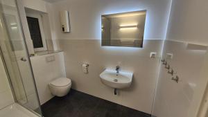 Wohnung zentral zwischen Gladbeck und Buer في غلادبك: حمام مع حوض ومرحاض ومرآة