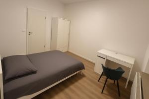 Wohnung zentral zwischen Gladbeck und Buer في غلادبك: غرفة نوم بها سرير ومكتب وكرسي