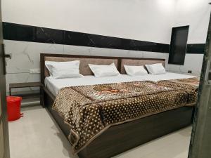 a bedroom with a large bed with a cheetah blanket at Hotel Sudha Palace in Khātu