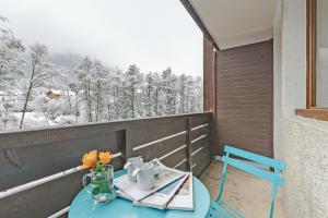 a blue table with a vase of flowers on a balcony at Chamonix Sud - Grepon 102 - Happy Rentals in Chamonix-Mont-Blanc +13 photos