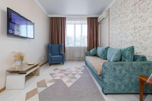 a living room with a couch and a tv at Уютная квартира рядом с Батырмол и Баянтау in Pavlodar