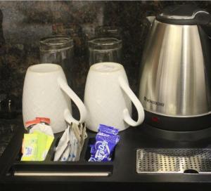 dos tazas blancas sentadas en un mostrador junto a una licuadora en Aashiyana Studio Homestay, en Solan