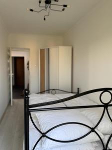 una camera da letto con un letto con lenzuola bianche e un lampadario a braccio di Przytulny a Bielsko-Biała Altre 12 foto