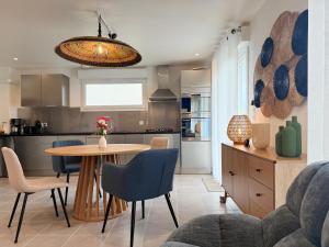 eine Küche und ein Esszimmer mit Tisch und Stühlen in der Unterkunft La Rose des Vents in Valence